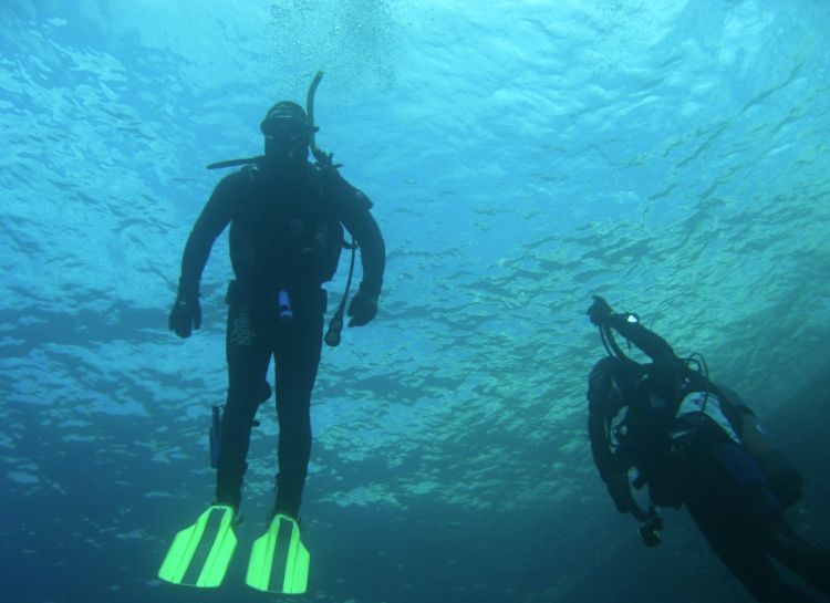 Two divers in clear blue water off Malta