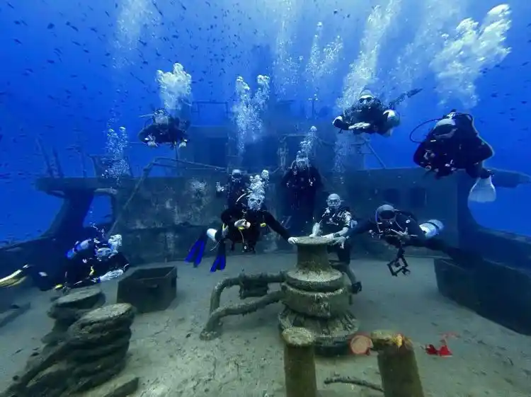 Group of divers and instructors on the stern of the Um El Faroud wreck in Malta
