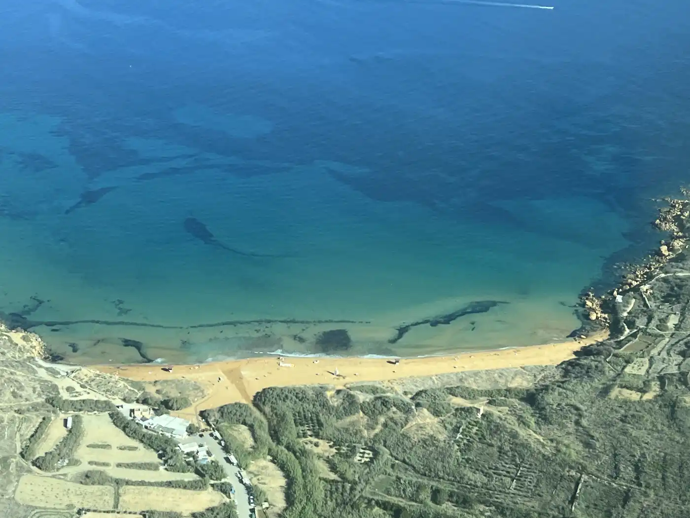 Ramla l-Hamra in Gozo, with red sand running into pale turquoise water